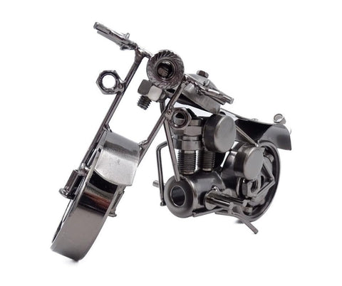 Metalinė motociklo figūrėlė antracito spalvos, surinkta iš veržlių ir varžtų, priekio kampu rodoma variklio detalė