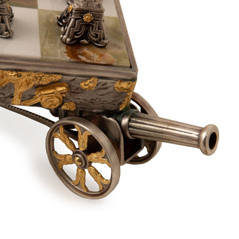 Miniatiūrinė patranka su auksuotais ratlankiais ir marmuriniu viršumi, matoma metalo rato ir vamzdžio detalė