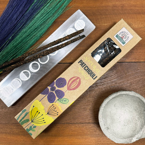 Patchouli smilkalai dėžutėje su permatomu langeliu, dvi tamsios masala lazdelės ant metalinio laikiklio