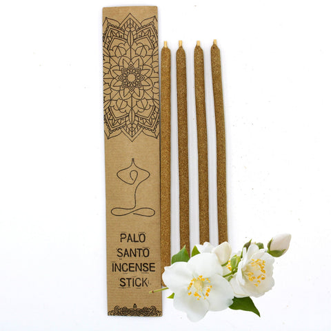 Palo Santo smilkalai — keturios rudos lazdos šalia kraft dėžutės su mandalos piešiniu ir baltų žiedų
