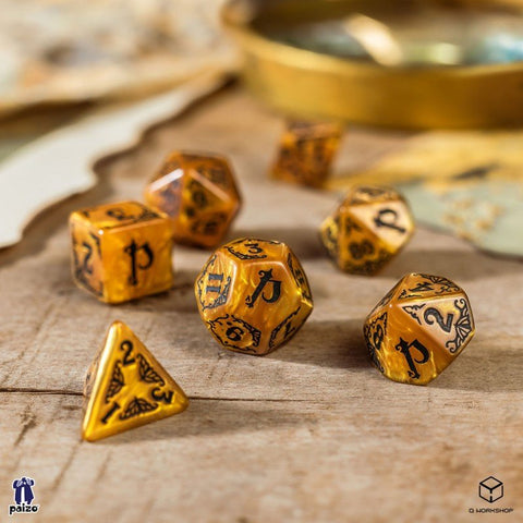RPG kauliukai 7 vnt., Q Workshop auksiniai marmuriniai komplektas su juodais skaičiais, arti išdėstyti ant medinės lentos