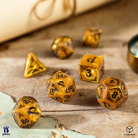 RPG kauliukai auksinės gintaro spalvos, 7 dalių rinkinys su juodais ornamentiniais skaičiais ant medinio stalo
