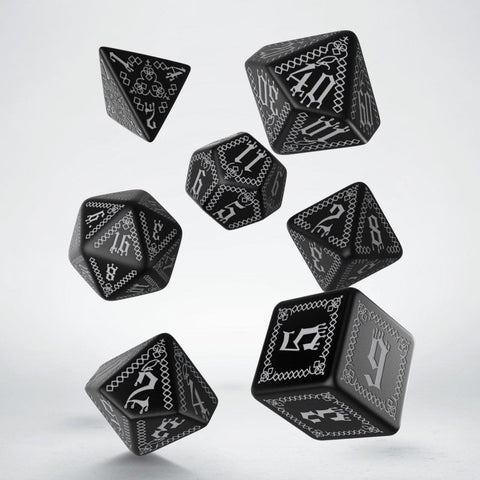 RPG kauliukai juodi su sidabriniais raižiniais, 7 vnt. rinkinys, laisvai skrendantys kampuotomis pusėmis, artimas planas