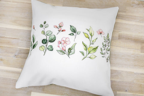 Pagalvėlė baltos spalvos 45×45 cm su akvareliniu žalumynų ir rožinių žiedų raštu, rodoma iš priekio ant medinių grindų, unikalus motyvas