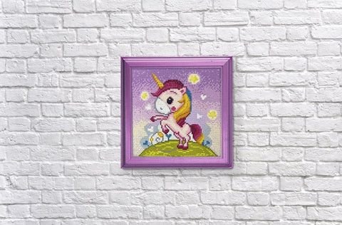 Deimantinė mozaika vienaragis rėmelyje, spalvota rožinė–violetinė paletė, 20×20 cm, pakabinta ant baltos plytų sienos