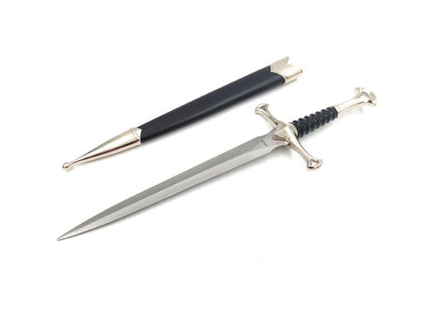 Durklas su sidabriniu ilgintu ašmeniu ir juoda odine makštele, metaline kryžmine rankena, parodytas kampu