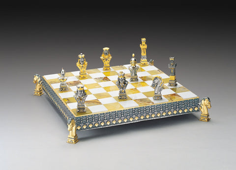 Šachmatai prabangūs aukso ir sidabro figūromis ant marmurinės baltai-auksinės lentos su arklių kojomis