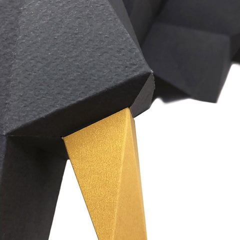 Stalelis su geometrine juoda viršutine dalimi ir aukso metaline koja, artima kampo detalė