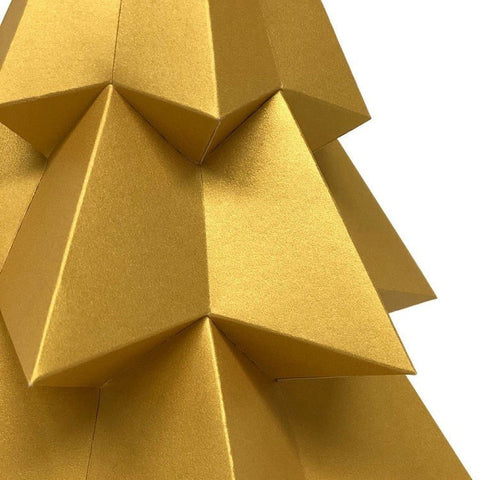 Popierinė eglutė, auksinė blizgi, stambių geometrinių sluoksnių artimas kampuotas priartinimas, išryškinantis unikalią tekstūrą