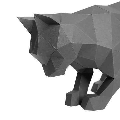 3D popierinė katė tamsiai pilka, žemu kampu užfiksuotas priekinis kampas, išryškina geometrines sulankstyto popieriaus briaunas ir detales