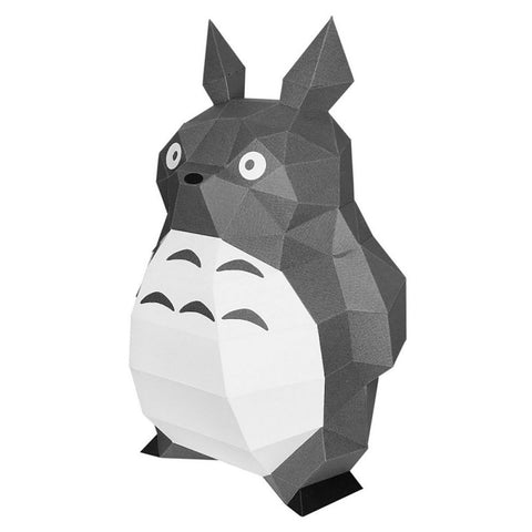 Popierinis Totoro modelis pilkai baltas, low‑poly stiliaus, trijų ketvirčių kampu, kaip dekoracija ant lentynos