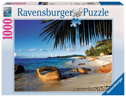 Dėlionė Ravensburger 1000 dalių, dėžutė su tropiniu paplūdimiu, kabančiomis palmėmis virš smėlio ir uolomis