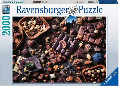 Ravensburger dėlionė 2000 dalių — iš arti rodoma stalinė kompozicija su įvairiais šokoladiniais saldainiais ir riešutais