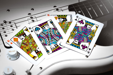 Kortos – keturi karaliai ryškiais raštais ant baltos elektrinės gitaros, priekio kampu išdėstytos ir kontrastuojančios
