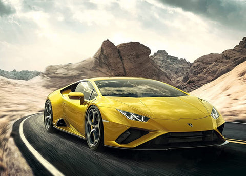 Lamborghini Huracán geltonas sportinis automobilis priekinis trijų ketvirčių kampas, važiuoja vingiuotu kalnų keliu