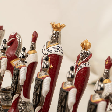 Šachmatų figūros raudonos ir baltos su auksiniais akcentais, artimas karaliaus bei sargybinių detalus vaizdas, rankų darbo dekoras