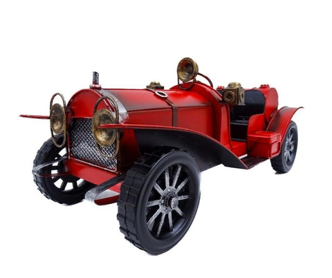 raudonas metalinis vintažinis modelinis automobilis, artimas priekinis kampo rodinys pabrėžiantis groteles ir ratus