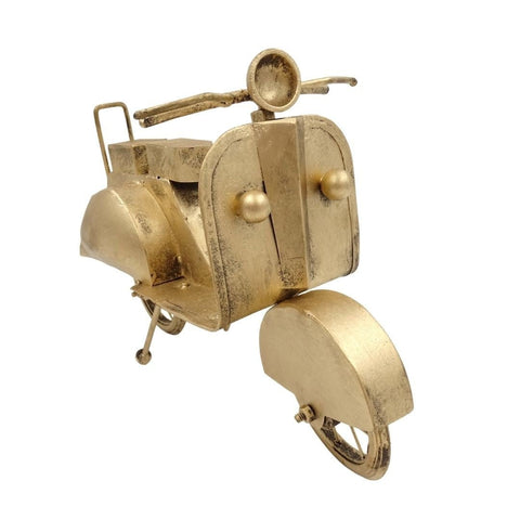 Metalinis auksinis retro motoroleris, stalo dekoracija, užfiksuotas iš trijų ketvirčių priekinio kampo su grubiu sendinto paviršiaus akcentu