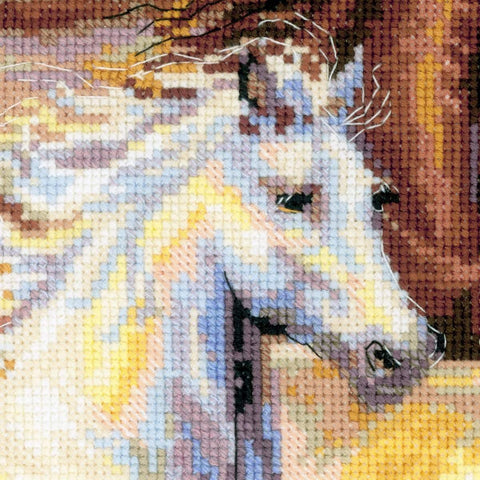 kryželių rinkinys – detali žirgo galvos artinys, matomos pastelinės geltonos, mėlynos ir rudos siūlių tekstūros