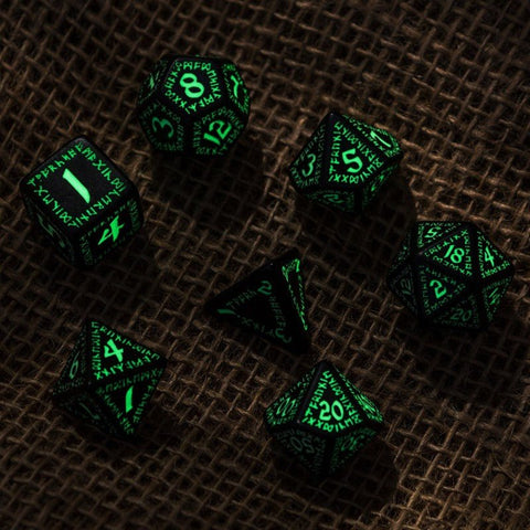 RPG kauliukai juodi su žalsvai švytinčiomis runomis, 7 dalių rinkinys, parodytas iš viršaus ant tekstūruoto audinio fono