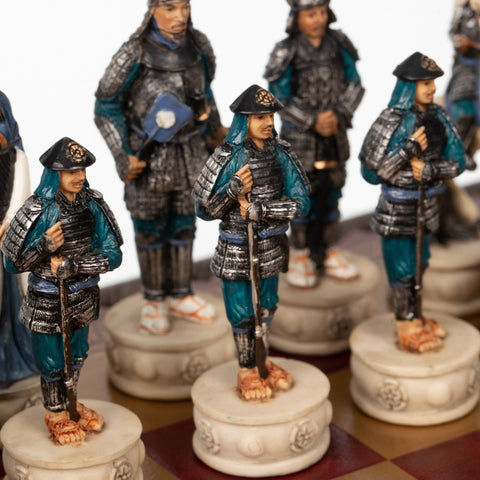 šachmatų figūra samurajus iš rankų dažyto rinkinio, mėlynos‑sidabrinės šarvų detalės ir raižyti balti pagrindai