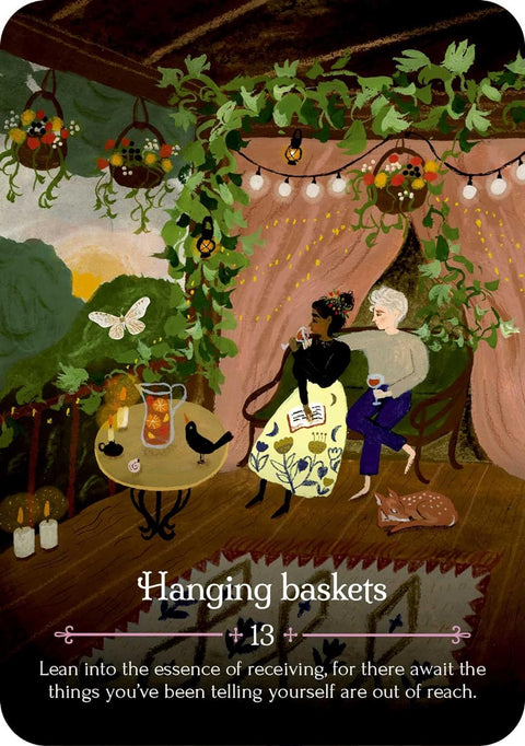 Orakulų korta Hanging Baskets, iliustracija su kabinančiais gėlių krepšiais, vijoklėmis ir pora prie staliuko terasoje