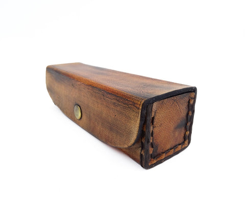 Odinis pieštukų dėklas rudos spalvos, rankų siūtas stačiakampis su senoviniu patinu ir metaliniu snapu, parodytas iš šono tekstūrai ir užsegimui