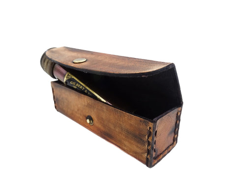 Odinis rašiklių dėklas rudos sendintos odos, atidarytas kampu, matomas juodas pamušalas ir žalvarinis spaustukas