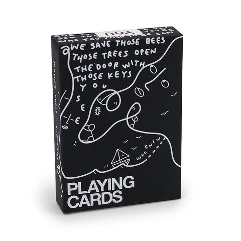 Kortos juodame dėkle su balta piešiniu ir dideliu PLAYING CARDS užrašu, parodytos iš priekio ant balto fono
