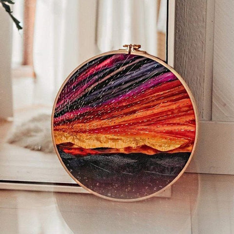 Siuvinėjimo rėmas, rankų darbo saulėlydžio motyvas ryškiomis oranžinėmis ir violetinėmis siūlėmis, 20 cm