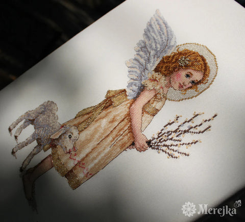 Siuvinėtas angelas Merekja, auksinės ir baltos spalvos, smulkūs kryželių darbai su ėriuku, arti kampinis kadras