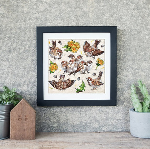 Siuvinys – kvadratinis rėme sparnų ir pienių motyvas, juodas rėmas 30×30 cm, paruoštas pakabinti