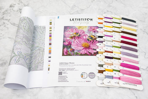 Siuvinėjimo rinkinys Letistitch Honey Blooms su spalvotų siūlų kortelėmis ir išvyniota schema, rodoma iš viršaus