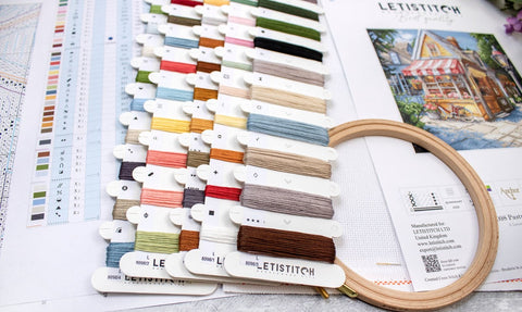 Siuvinėjimo siūlai Letistitch spalvų kortelėse: 30 įvairesnių atspalvių, arti nufotografuota, su mediniu lankeliu ir schema