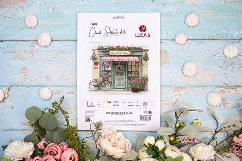 Kryželių rinkinys LUCA‑S The Little Gift Shop — paketo priekis ant melsvos sendintos lentos, apsuptas gėlių ir saldainių