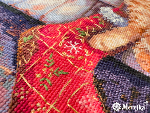 Siuvinėjimas Merejka: artima kampinė raudonos kryželių aplikacijos detalė su auksinėmis siūlėmis ir žaliomis akcentinėmis dygsnėmis