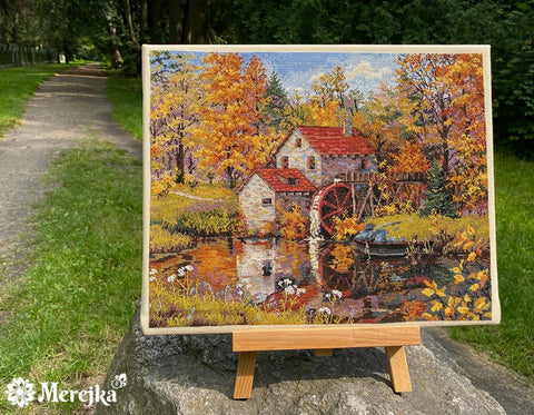 Siuvinėtas paveikslas rudeninis malūno ir tvenkinio motyvas, rankų darbas 30×25 cm ant mažo stovo lauke