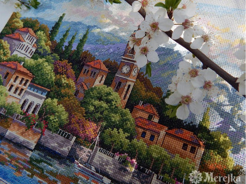 Siuvinėjimo rinkinys Merejka — spalvota miesto panorama prie kranto su laivu ir arti matoma žydinčios vyšnios šaka, detalus kryželių raštas