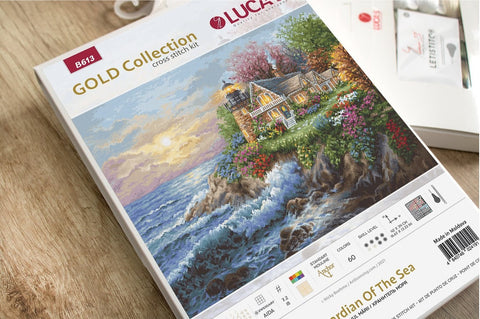 Kryželių rinkinys LUCA Gold Collection — pakelio priekinė dalis su jūros krantinės kotedžo piešiniu ir dydžio bei spalvų informacija