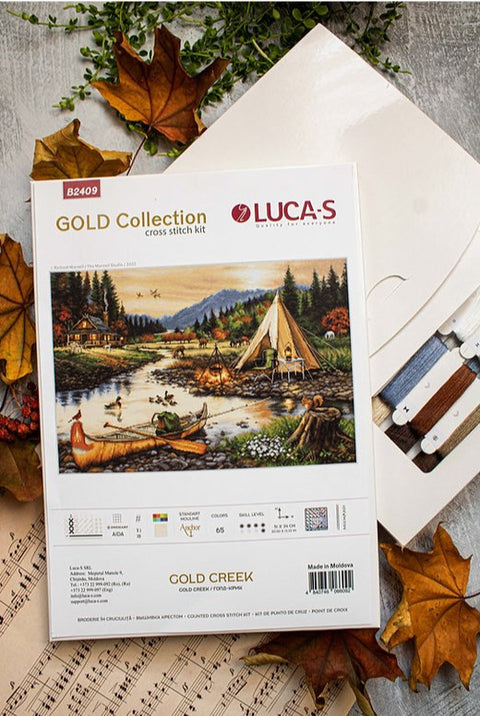 kryželių rinkinys LUCA-S Gold Creek su aida, spalvotų siūlų kortele ir schema, pakuotė pateikta ant rudens lapų