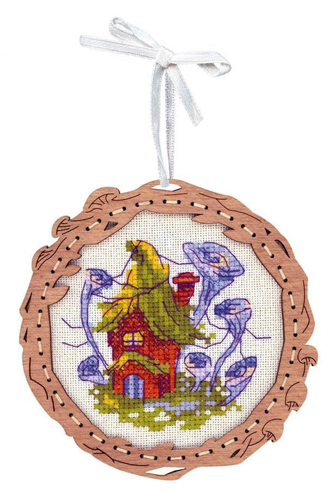 Siuvinėjimo ornamentas mediniame rėmelyje su spalvotu nameliu ir baltu pakabinimo kaspinu, skirtas eglutei