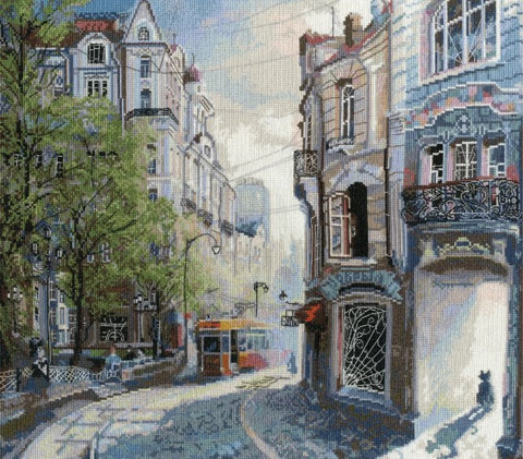 Siuvinėtas paveikslas „Miesto gatvė“, pastelinės mėlynos ir smėlinės tonacijos, 40×40 cm, arti užfiksuota tekstūra ir troleibuso detalė