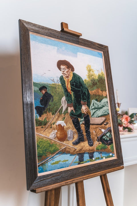 Gobelenas su tamsiu mediniu rėmu ant molberto, klasikinė kaimo scena iš trimačio kampo, unikalus galerijos variantas