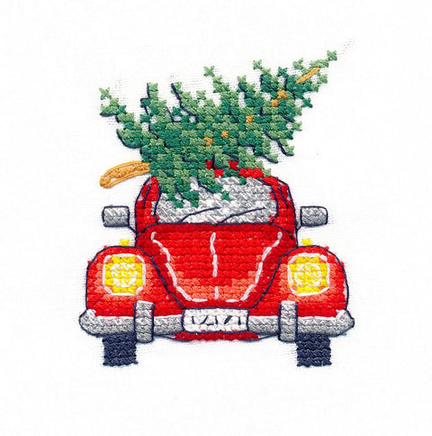 Siuvinys raudonas retro automobilis iš priekio su ant stogo pritvirtinta žalia Kalėdų eglute, 7×7 cm variantas
