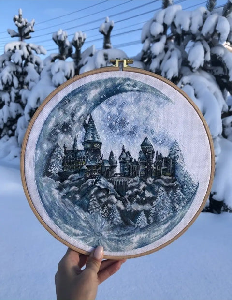 Kryželiu siuvinėjimas su mėlyno‑pilka žiemos pilimi mediniame 25 cm lankelyje, fotografuotas lauke ant sniego