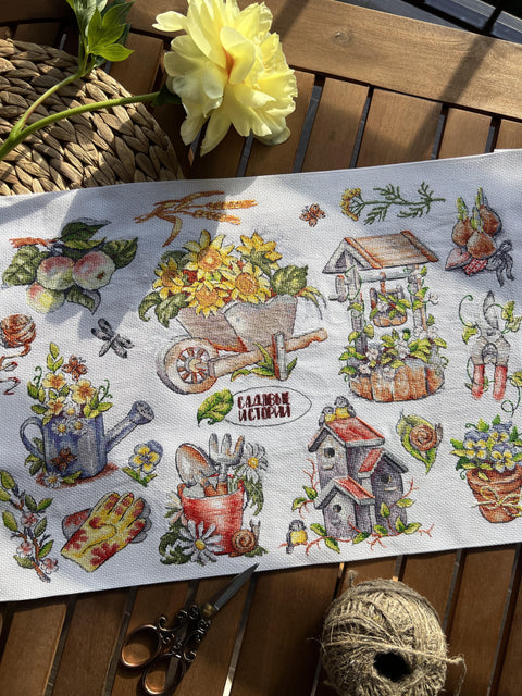 Siuvinėjimo audinys su sodų motyvais, baltas 40×50 cm, lauko stilizuotas kadravimas saulėje su žirklių ir virvės rekvizitais