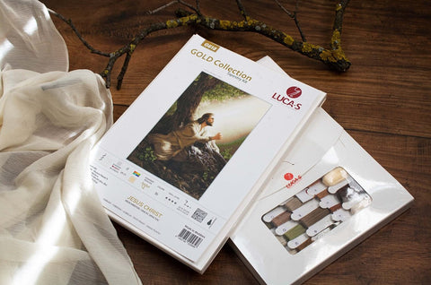 Siuvinėjimo rinkinys Gold Collection Jėzus Kristus – tapiserijos komplektas su siūlų paketu ir instrukcija, pakuotė ant medinio stalo