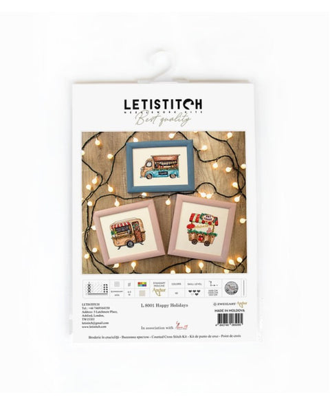 Kryželių rinkinys LETISTITCH "Happy Holidays" – trys mini ornamentai (maisto furgonėliai) ant pakuotės, dekoratyvios girliandos fone