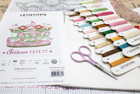 Kryželių siuvinėjimo rinkinys Letistitch 'Baby Carousel' su spalvotomis siūlų kortelėmis ir rožinėmis žirklėmis.