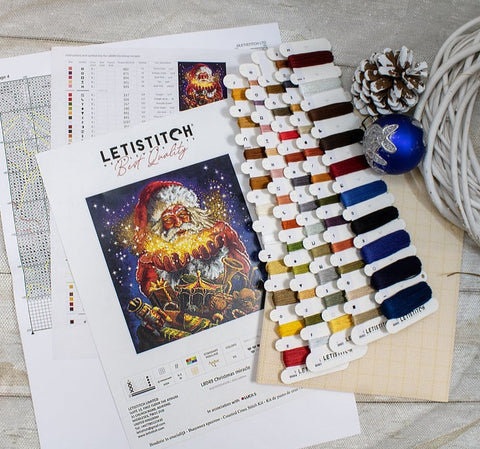 Kryželių rinkinys LETISTITCH su Kalėdų Senelio piešiniu, detalizuota schema ir spalvotų siūlų kortelėmis, parodytas viršuje eskizuojant darbą